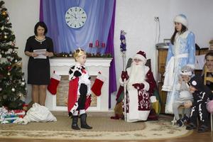 Morning party in kindergarten.A boy dressed as a king reads poetry at a holiday in kindergarten. photo