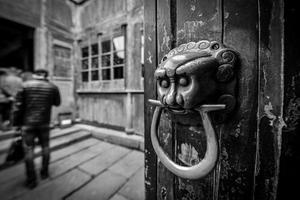 Traditional lion shape door knocker in old house in ancient Chinese town photo