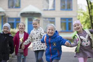 bielorrusia, el ciudad de gómel, mayo 10, 2019. abierto día en kindergarten.feliz preescolares en el calle. niños participación manos saltando un grupo de seis año antiguo amigos. foto