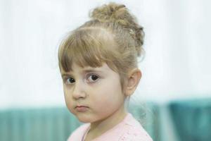 Belarus, the city of Gomil, December 27, 2018. Morning party in kindergarten.The face of a serious three year old girl. photo