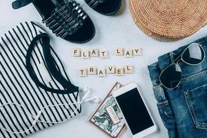 Travel flat lay. Summer women's clothing, accessories. T-shirt, summer sandals, shorts, rattan bag. photo