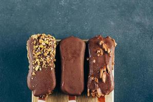 Top view of Eskimo ice cream in chocolate glaze on stone background. Yummy sweet food snack treat. Top view, copy space photo