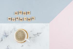 Cup of coffee, text Good Morning on tricolor background. Flat lay, copy space, top view photo