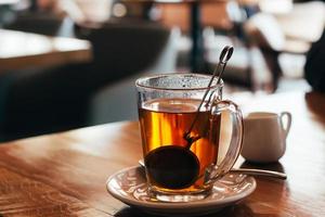 Glass Mug of hot tea at a cafe with blurred background. Natural light. photo
