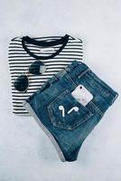 Top view of summer women's clothing - Striped t-shirt, blue denim shorts and accessories photo