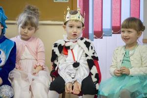 unny boy in the carnival costume of the king at the Christmas matinee in kindergarten. photo