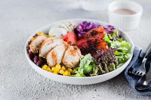 sano almuerzo ensalada con pollo, huevo, Tomates, lechuga, rojo frijoles, rojo repollo, salsa foto