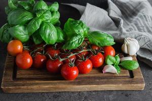 Healthy food product. Organic Cherry Tomatoes with basil, garlic . Top view photo