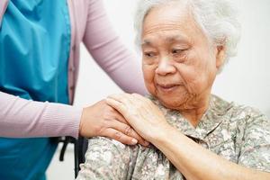 Caregiver help Asian elderly woman disability patient sitting on wheelchair in hospital, medical concept. photo