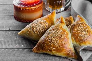 Samosas samsa with meat, glass of tea on wooden table background. East Asian Dish. Ramadan food photo