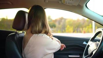 bellissimo ragazza nel bicchieri fissaggio auto sicurezza posto a sedere cintura mentre seduta dentro di veicolo prima guida video