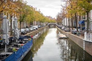 The Netherlands, Delft, October 2022. Oude Delft canal in Delft with river restaurant and bridge photo