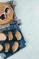 Summer women's clothing and accessories. Animal print t-shirt, blue denim shorts, organic rattan bag photo