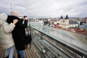 Mother with daughter making photo from panorama view of city.