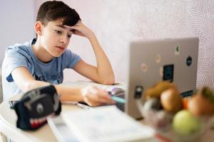 Young teenage boy having video conference call with pupil using webcam. Online education and e-learning concept. Home quarantine distance learning. photo