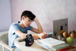 Young teenage boy having video conference call with pupil using webcam. Online education and e-learning concept. Home quarantine distance learning. photo