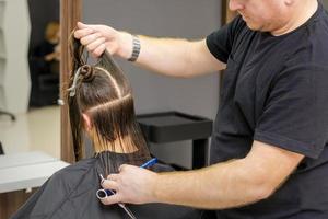 Male hairdresser splits long hair photo