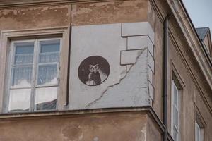 mural of an owl on the wall of an old historic tenement house in Warsaw, Poland photo