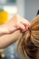 Female hairdresser styling blonde hair photo