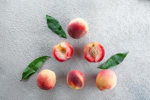 Fresh peaches. Peaches on light concrete background. Flat lay, top view. photo