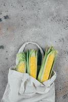 Fresh corn on cobs in a tissue bag. Zero waste concept. Top view, copy space, flat lay. photo