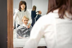 Hairdresser puts on transparent cape photo