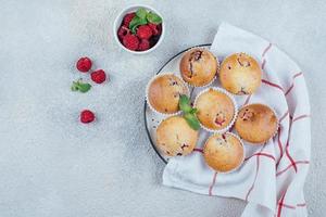 Delicious breakfast food concept. Raspberry muffins on concrete table. Top view, flat lay photo