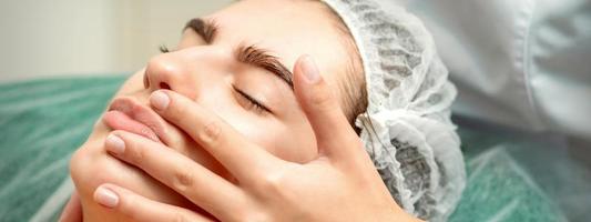 Young woman receiving facial massage photo