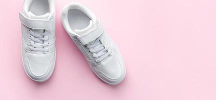 White sneakers on a pink background. photo