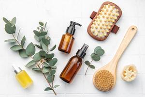 Spa treatment concept. natural spa cosmetics products with eucalyptus oil,, massage brush, eucalyptus leaf. photo