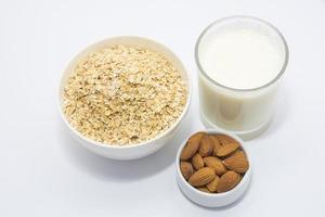 sano desayuno ingredientes vaso de leche, almendra nuez y avena foto