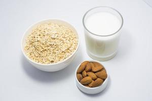 sano desayuno ingredientes vaso de leche, almendra nuez y avena foto