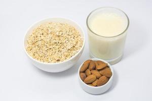 Healthy breakfast ingredients glass of milk, Almond nut and oats photo