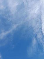 Beautiful white clouds on deep blue sky background. Large bright soft fluffy clouds are cover the entire blue sky. photo