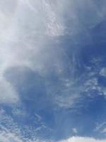 Beautiful white clouds on deep blue sky background. Large bright soft fluffy clouds are cover the entire blue sky. photo