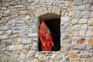 un verdugo vestido en rojo en pie en el ventana de un castillo foto