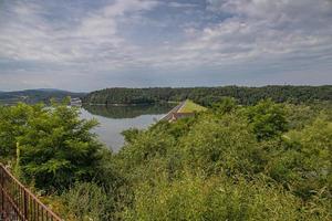 paisaje de el laguna a el represa en dobczyce en Polonia en un calentar verano nublado día foto