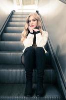 an attractive woman sitting on an escalator photo