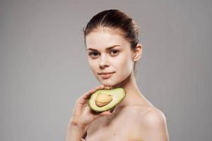 Beautiful brunette naked shoulders avocado in clean skin hand photo