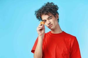 man in red t-shirt curly hair dry snack japanese fast food photo