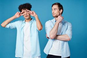 two men in shirts stand next to communication blue background photo