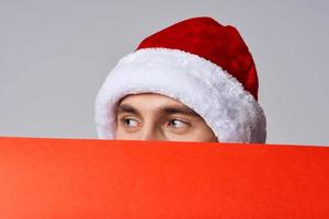 emotional man in New Year's clothes holding a banner holiday light background photo