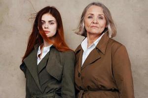 young and old women stand side by side autumn fashion studio isolated background photo