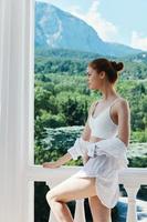 attractive young woman in lingerie on the balcony beautiful view from the window Summer day photo