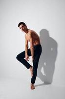 Side view of a guy with a raised leg up on a light background photo