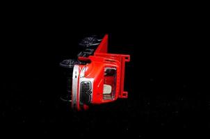 Red toy truck on black background photo