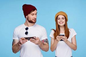 young couple in hats with phones in hands fashion communication photo