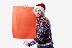 handsome man in New Year's clothes holding a banner holiday light background photo