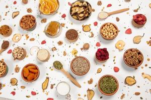 Healthy vegetarian food concept. Assortment of dried fruits, nuts and seeds on white background. Top view. photo