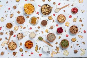 Healthy vegetarian food concept. Assortment of dried fruits, nuts and seeds on white background. Top view. photo